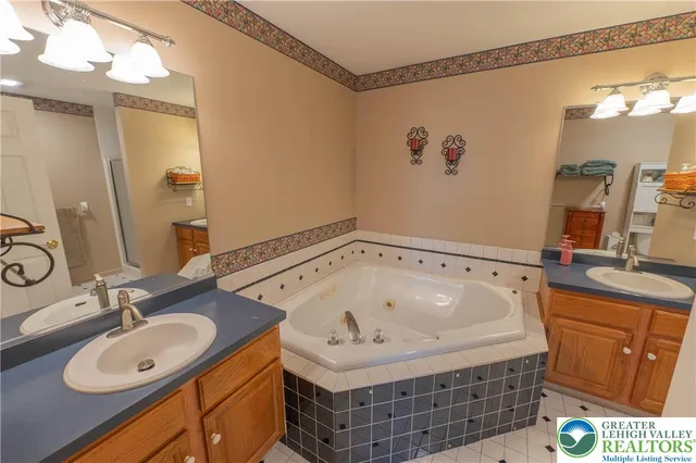 a bathroom with a tub sink and mirror