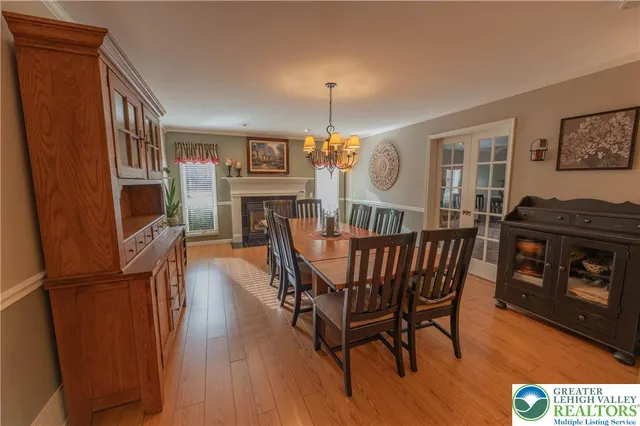 a dining room with furniture a chandelier and wooden floor
