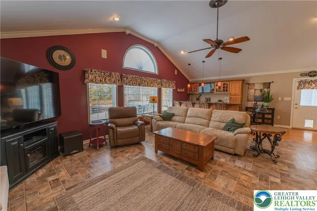 a living room with furniture a flat screen tv and a wall painting