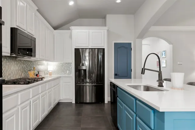a kitchen with sink a microwave and refrigerator