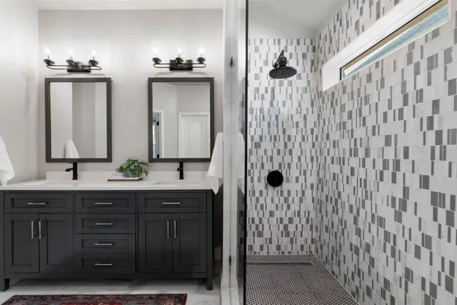 a bathroom with a granite countertop sink a mirror a vanity and a shower