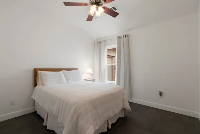 a bedroom with a bed and a ceiling fan