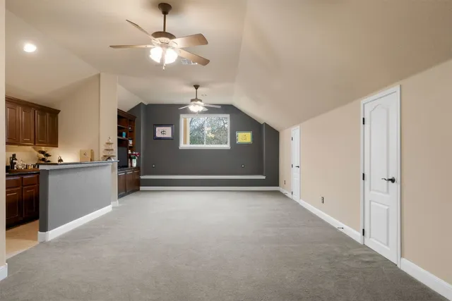 a kitchen with granite countertop a sink a stove and cabinets