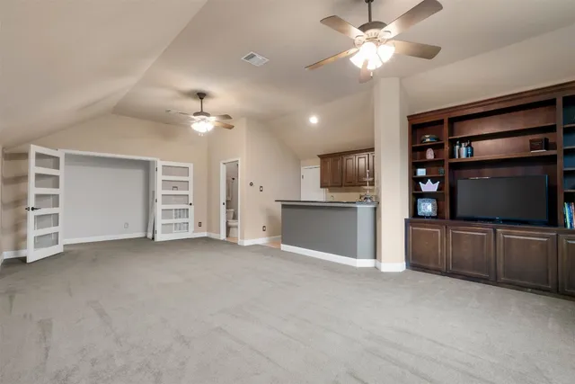 a view of an empty room with cabinet and a kitchen