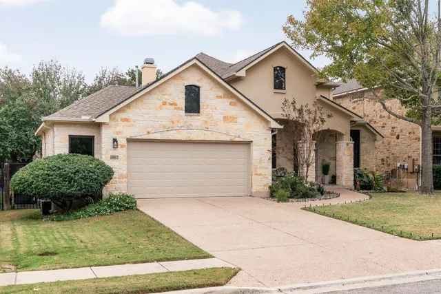 a front view of a house with a yard and garage