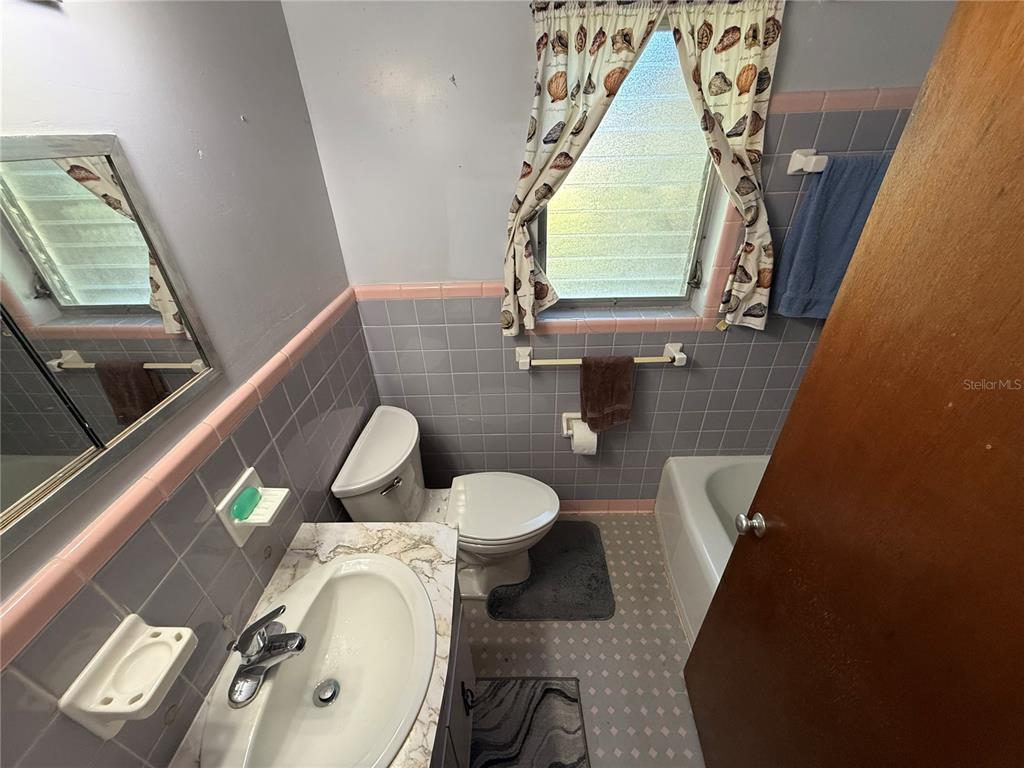 2200 Butler Street Leesburg, FL 34748 - Photo 15 of 32 a bathroom with a toilet sink and mirror