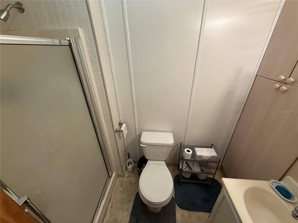 2200 Butler Street Leesburg, FL 34748 - Photo 20 of 32 a white toilet sitting next to a sink and a mirror