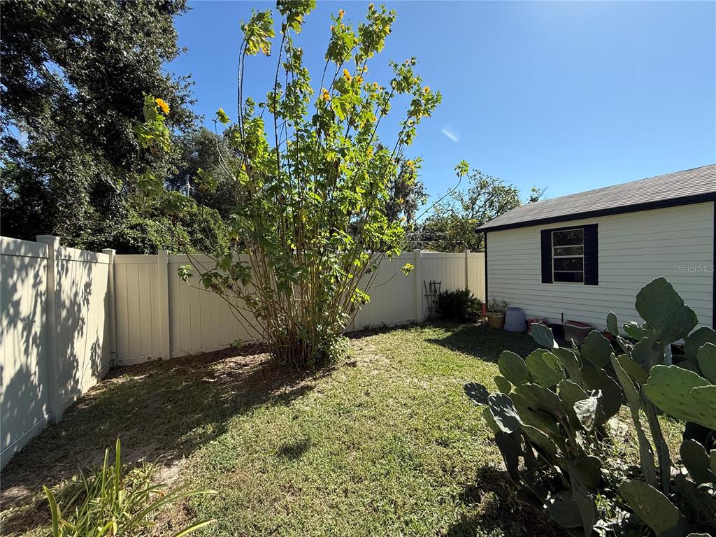 2200 Butler Street Leesburg, FL 34748 - Photo 29 of 32 a backyard of a house with table and chairs under an umbrella