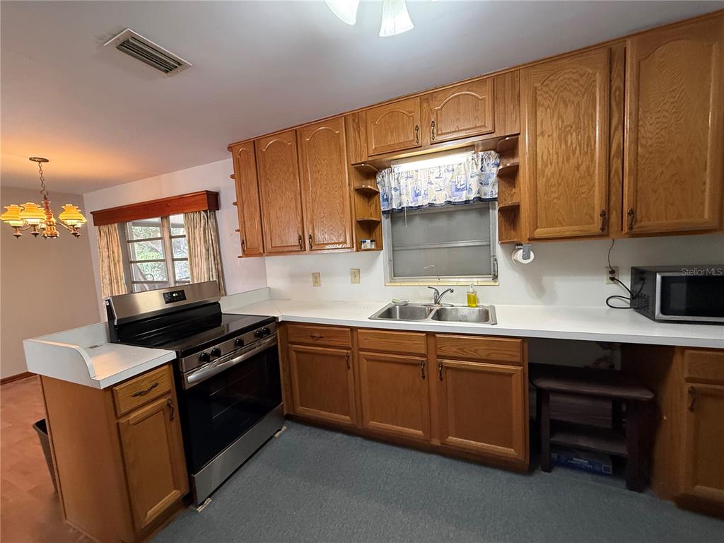 2200 Butler Street Leesburg, FL 34748 - Photo 9 of 32 a kitchen with stainless steel appliances granite countertop a sink stove and microwave