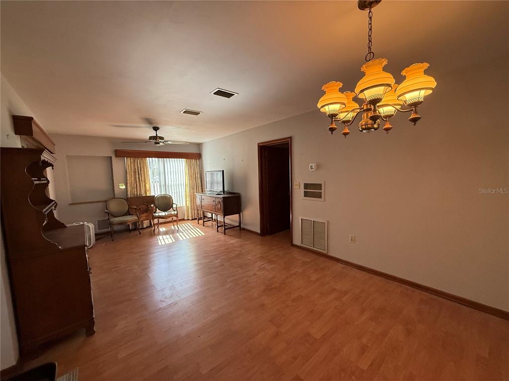 2200 Butler Street Leesburg, FL 34748 - Photo 10 of 32 a view of a livingroom with wooden floor and a ceiling fan