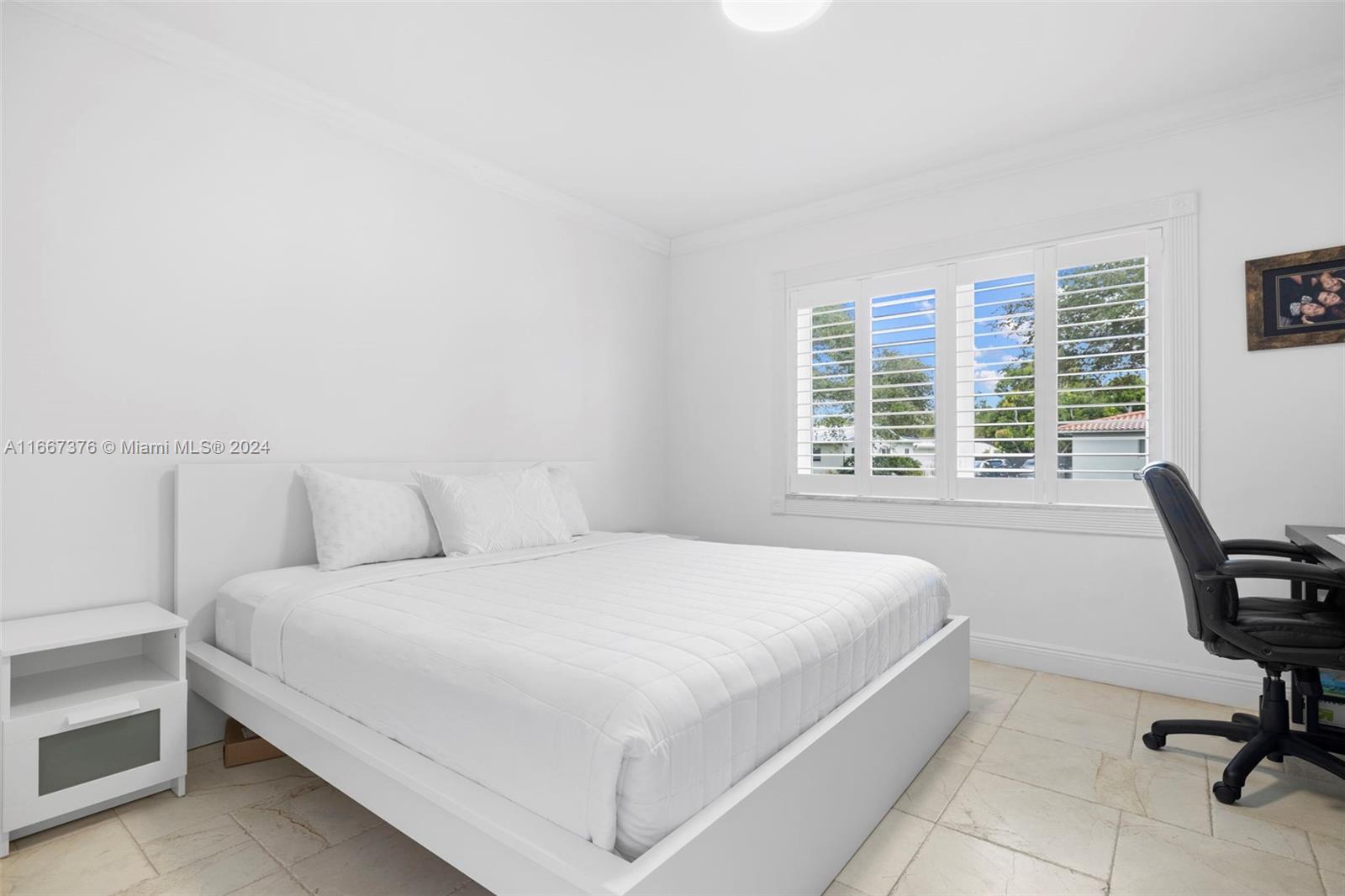 10005 Southwest 79th Avenue Miami, FL 33156 - Photo 12 of 32 a bedroom with a bed a chair and a large window