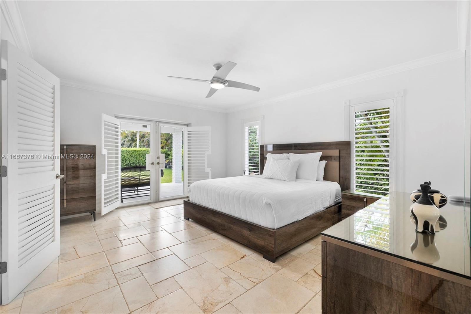10005 Southwest 79th Avenue Miami, FL 33156 - Photo 16 of 32 a bedroom with a bed and a chandelier