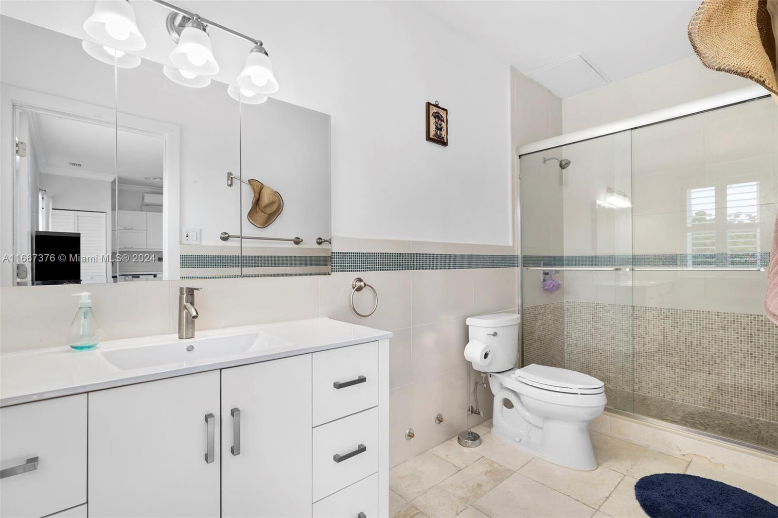 10005 Southwest 79th Avenue Miami, FL 33156 - Photo 22 of 32 a bathroom with a toilet a sink and mirror