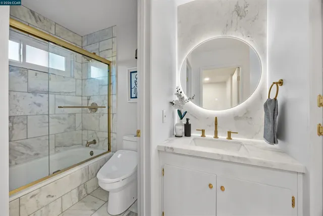 a bathroom with a toilet a sink and a large mirror