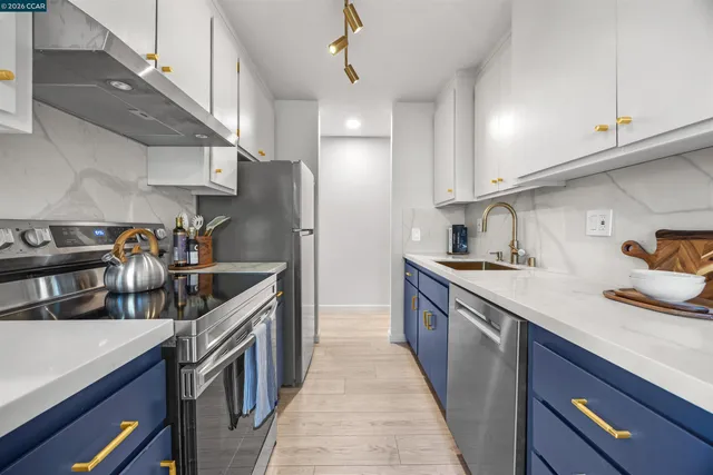 a kitchen with stainless steel appliances granite countertop a sink a stove and a refrigerator