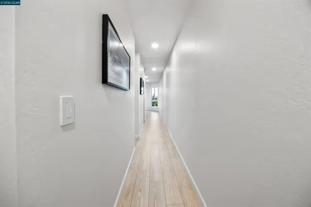 a view of a hallway with wooden floor