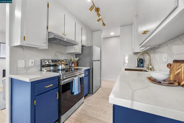 a kitchen with stainless steel appliances granite countertop a sink a stove and a refrigerator