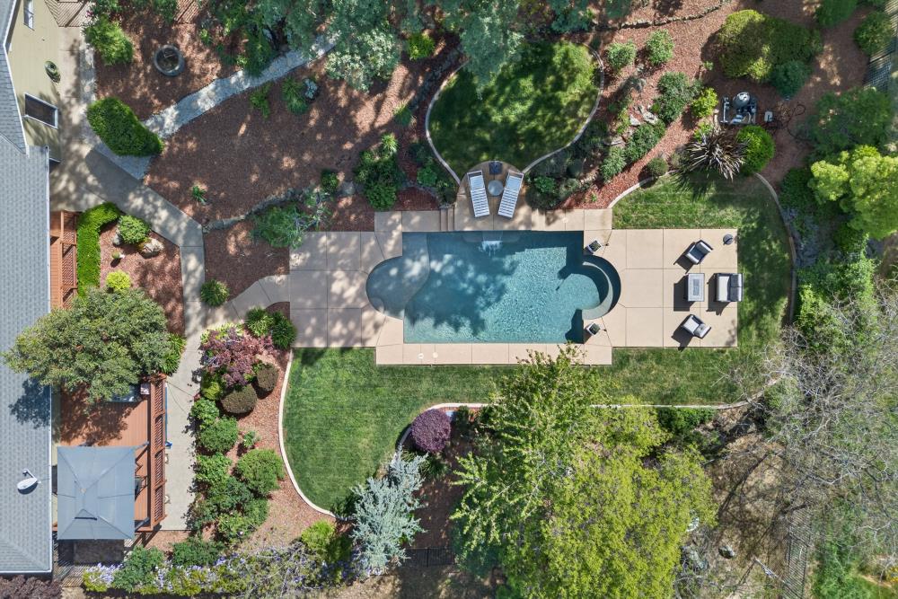 5560 Ralston Way Placerville, CA 95667 - Photo 42 of 78 Resort-style backyard featuring a freeform swimming pool with extensive hardscaping, manicured lawn, and mature landscaping