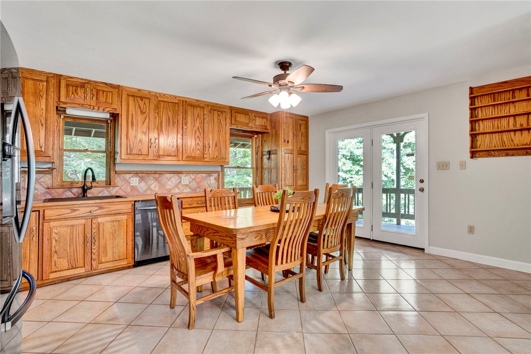 120 Patterson Ridge Road Salem, SC 29676 - Photo 9 of 46 A well-lit kitchen with natural wood cabinetry with a window bench and double French doors opening to the outdoors.