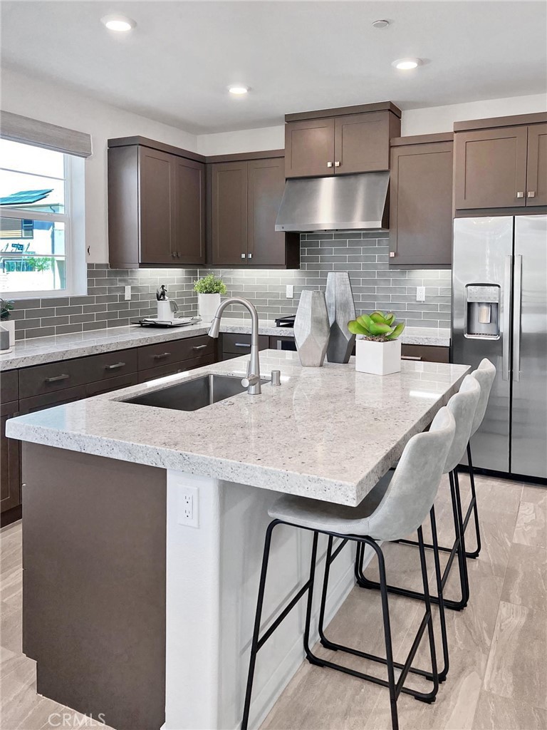 27105 Trail View Ln. Valencia, CA 91381 - Photo 3 of 30 a kitchen with stainless steel appliances granite countertop a kitchen island a stove a dining table and chairs