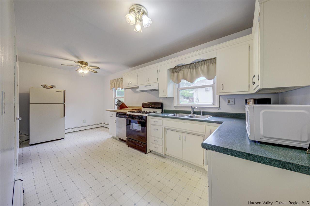 105 Gleneida Ridge Road Carmel, NY 10512 - Photo 16 of 35 a kitchen with granite countertop a refrigerator a sink dishwasher a stove and white cabinets with wooden floor