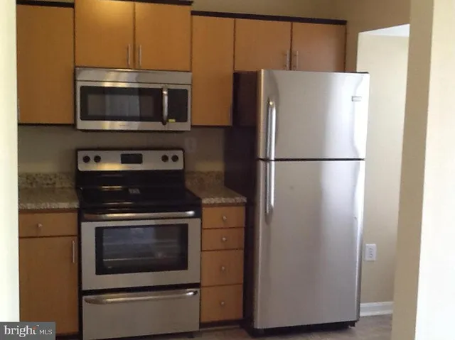 a white refrigerator freezer and a stove sitting inside of a kitchen