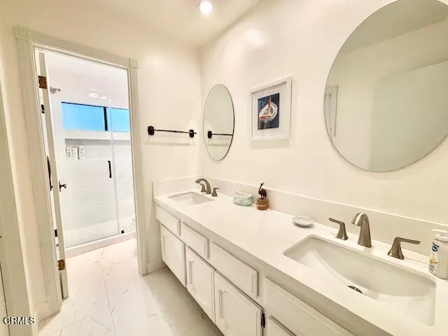 a en suite bathroom with a double vanity sink and a mirror