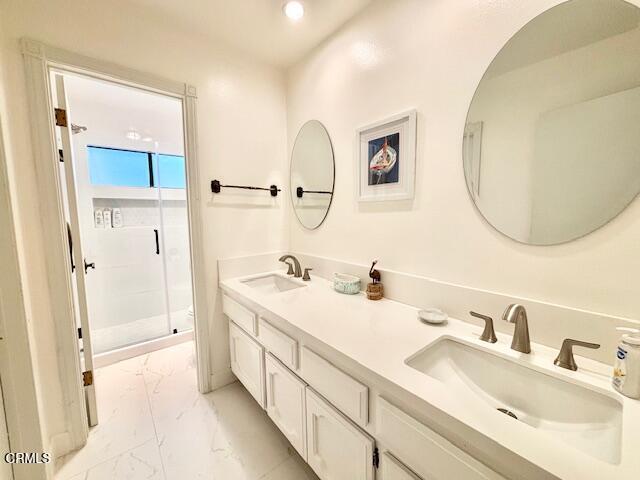 3949 Ocean Drive Oxnard, CA 93035 - Photo 20 of 24 a en suite bathroom with a double vanity sink and a mirror