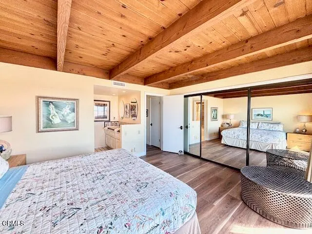 a bedroom with a large bed and wooden floor