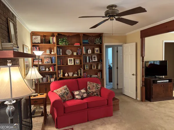 a living room with furniture a ceiling fan and a window