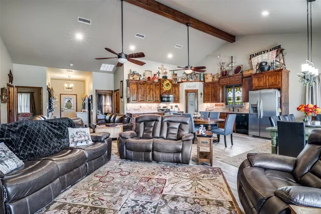 a living room with furniture kitchen view and a chandelier