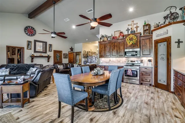 a room with stainless steel appliances kitchen island granite countertop furniture and a dining table