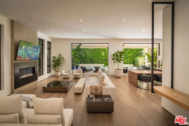 a living room with furniture fireplace and a large window