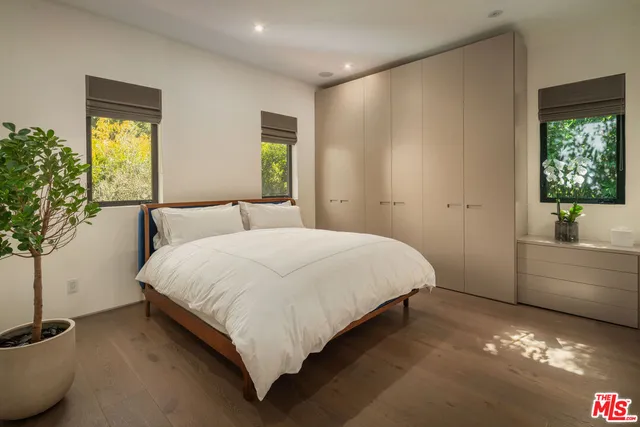 a bedroom with a bed and a potted plant