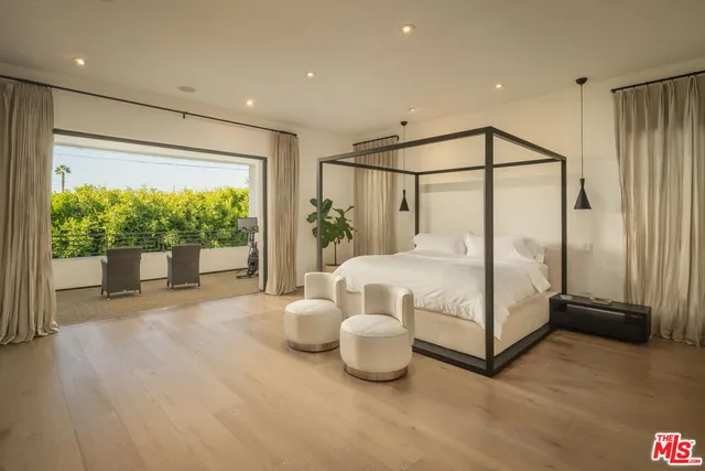 a bedroom with a bed and a large window