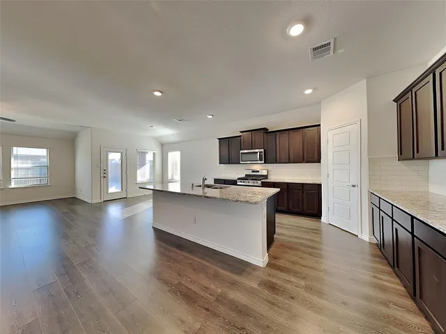 a kitchen with stainless steel appliances kitchen island wooden cabinets and granite counter tops