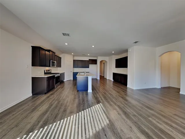 a view of kitchen with microwave a stove and wooden floor