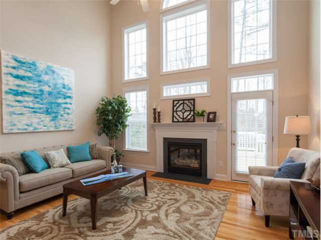 11545 Auldbury Way Raleigh, NC 27617 - Photo 3 of 25 Cozy Light-Filled Living Room features stunning windows, gas fireplace, hardwood floors, vaulted ceilings Den/Family/Great Room