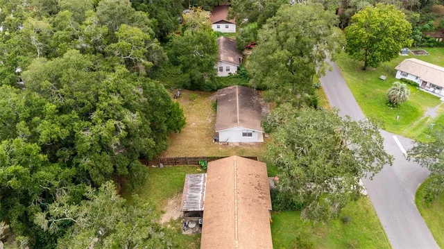 an aerial view of residential houses with outdoor space and trees