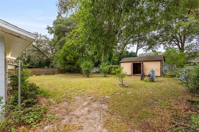 a view of a house with a yard and tree