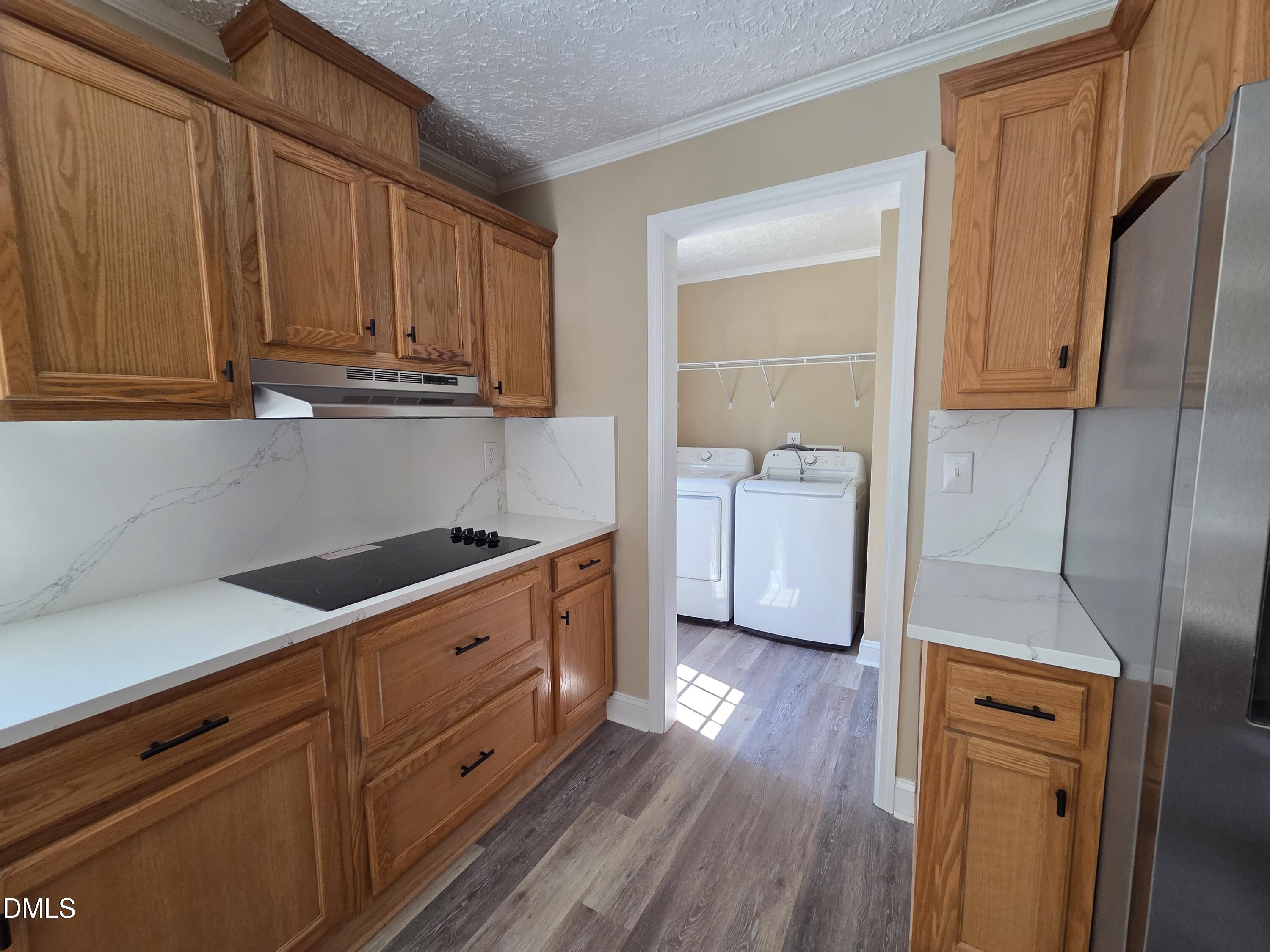 664 Glebe Road Henderson, NC 27537 - Photo 14 of 44 a kitchen with granite countertop wooden cabinets and white appliances