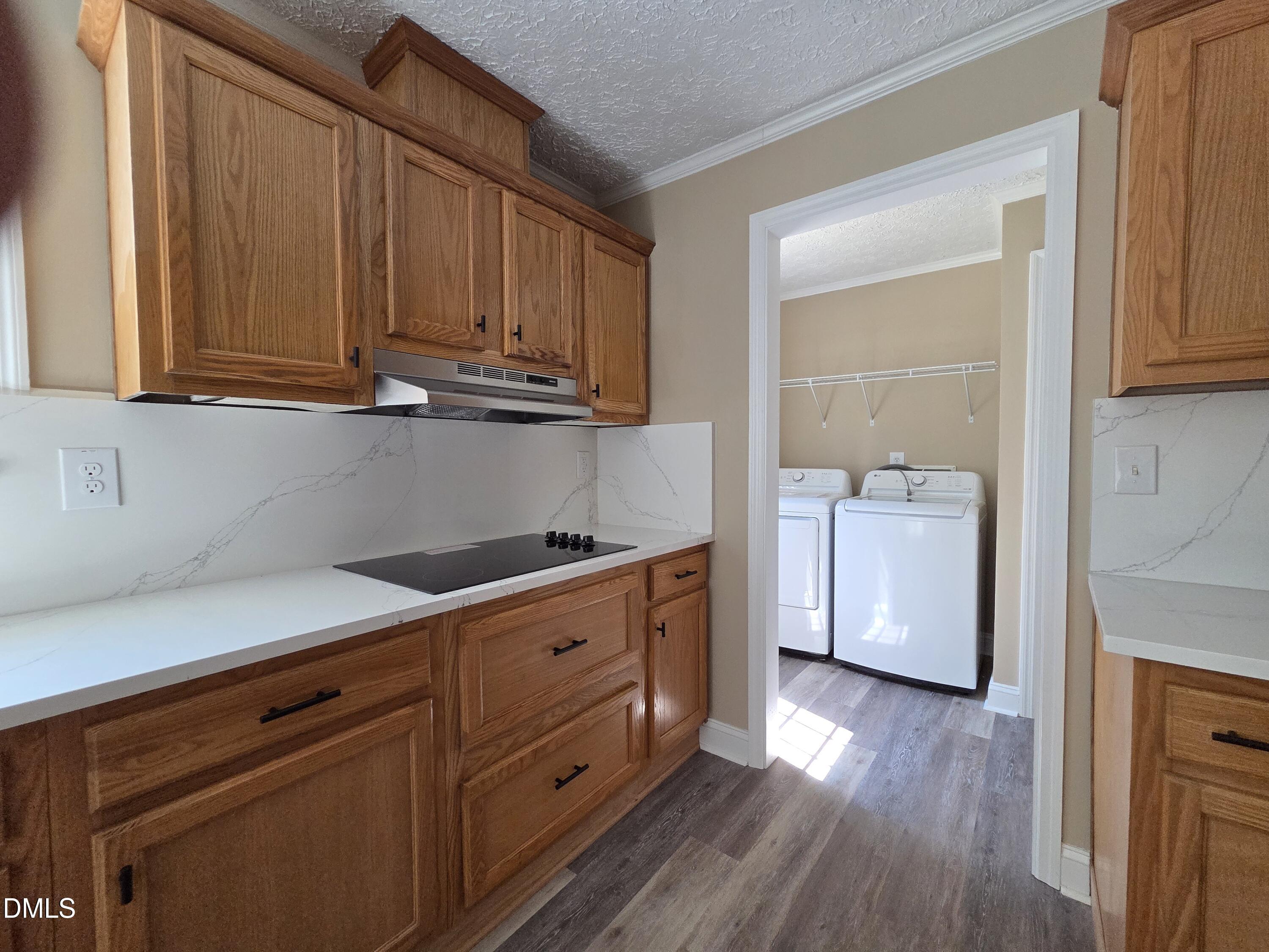 664 Glebe Road Henderson, NC 27537 - Photo 15 of 44 a kitchen with granite countertop wooden cabinets and white appliances