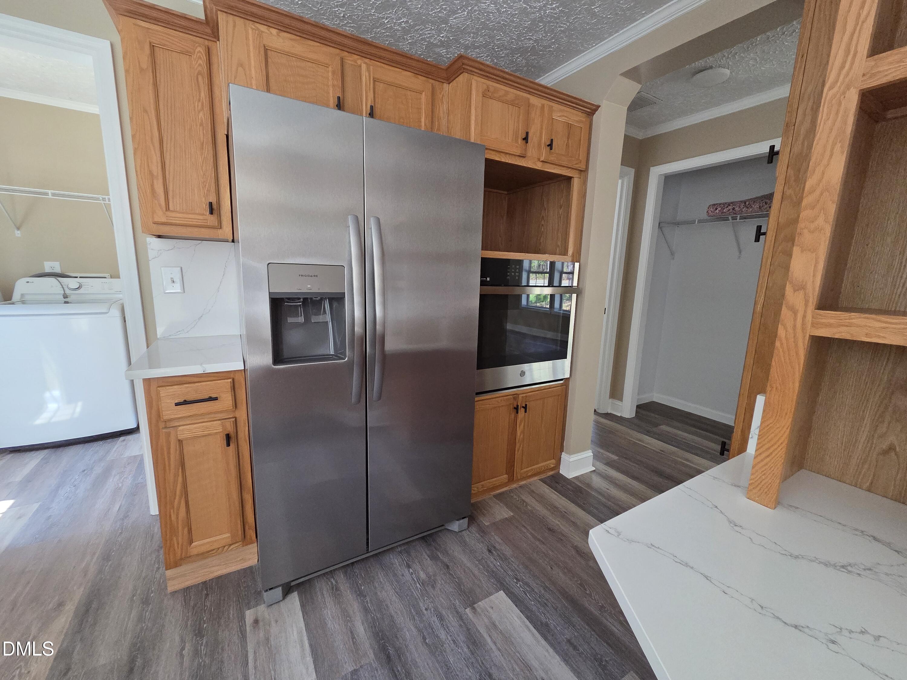 664 Glebe Road Henderson, NC 27537 - Photo 17 of 44 a kitchen with stainless steel appliances a refrigerator and wooden floor