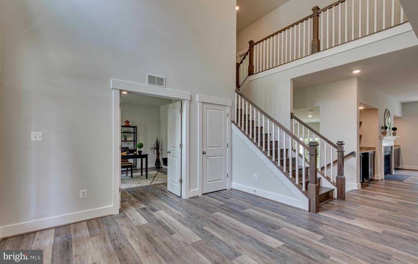 6709 Deep Run Trail Hanover, MD 21076 - Photo 5 of 12 an entryway with a hallway with wooden floor and stairs