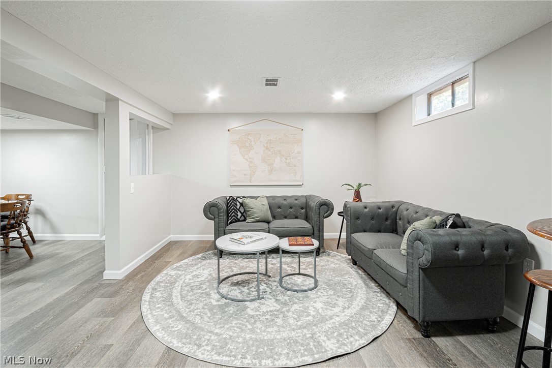 421 Hillman Road Akron, OH 44312 - Photo 22 of 27 Living room featuring a textured ceiling and light wood-type flooring