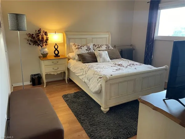 a bedroom with a bed and flat screen tv