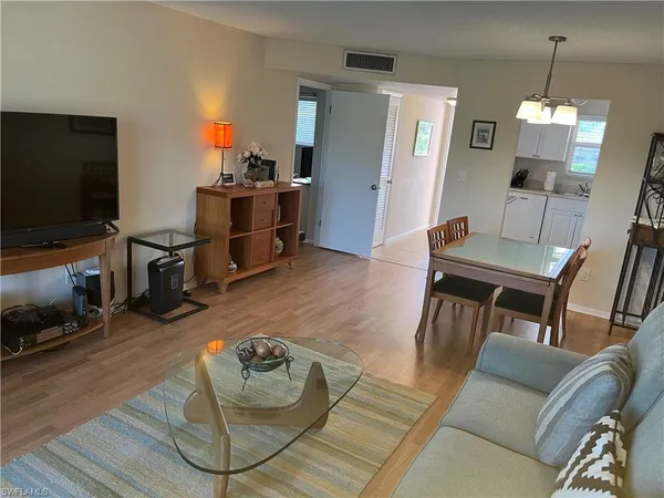a bedroom with a bed and flat tv screen on the dresser