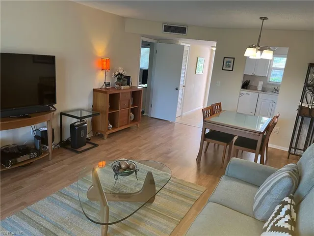 a bedroom with a bed and flat tv screen on the dresser