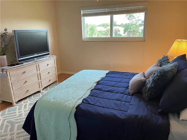 a bedroom with a bed and a potted plant
