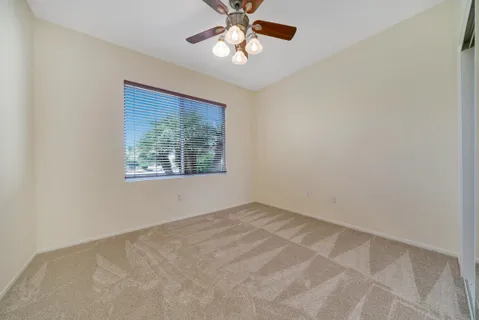 an empty room with a window and a fan